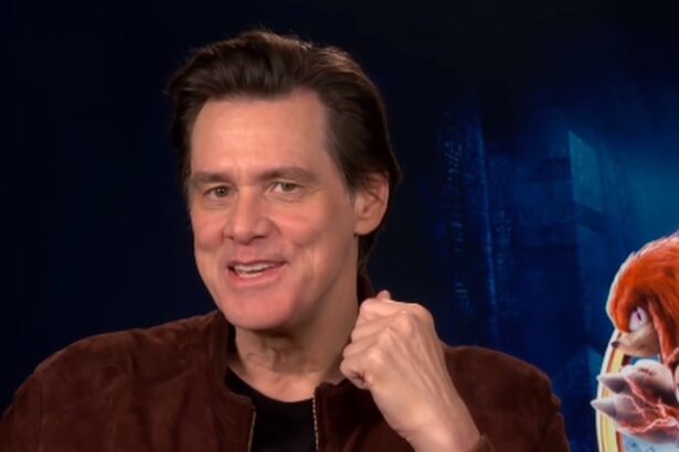 Jim Carrey em foto de reprodução, com a mão próxima ao queixo