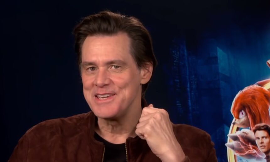 Jim Carrey em foto de reprodução, com a mão próxima ao queixo