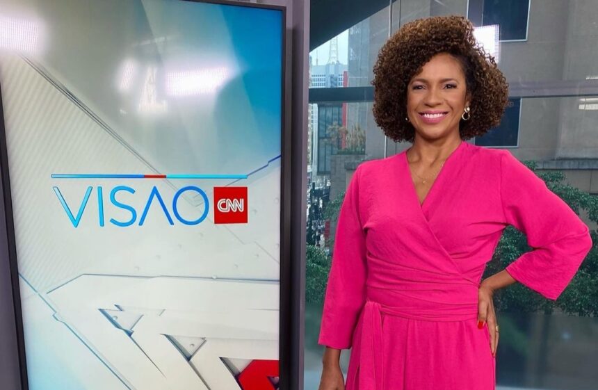 Luciana Barreto nos estúdios do Visão CNN, ao lado do telão