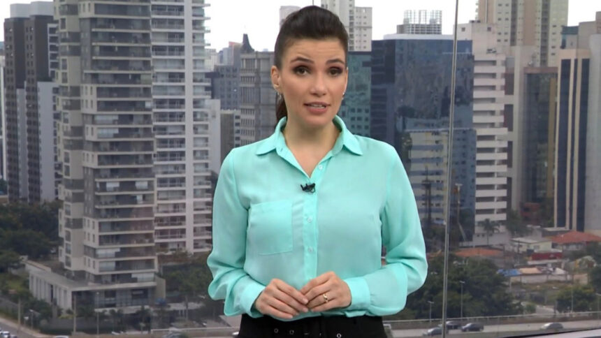 Sabina Simonato de blusa azul nos estúdios do SP1, durante chamada do jornal