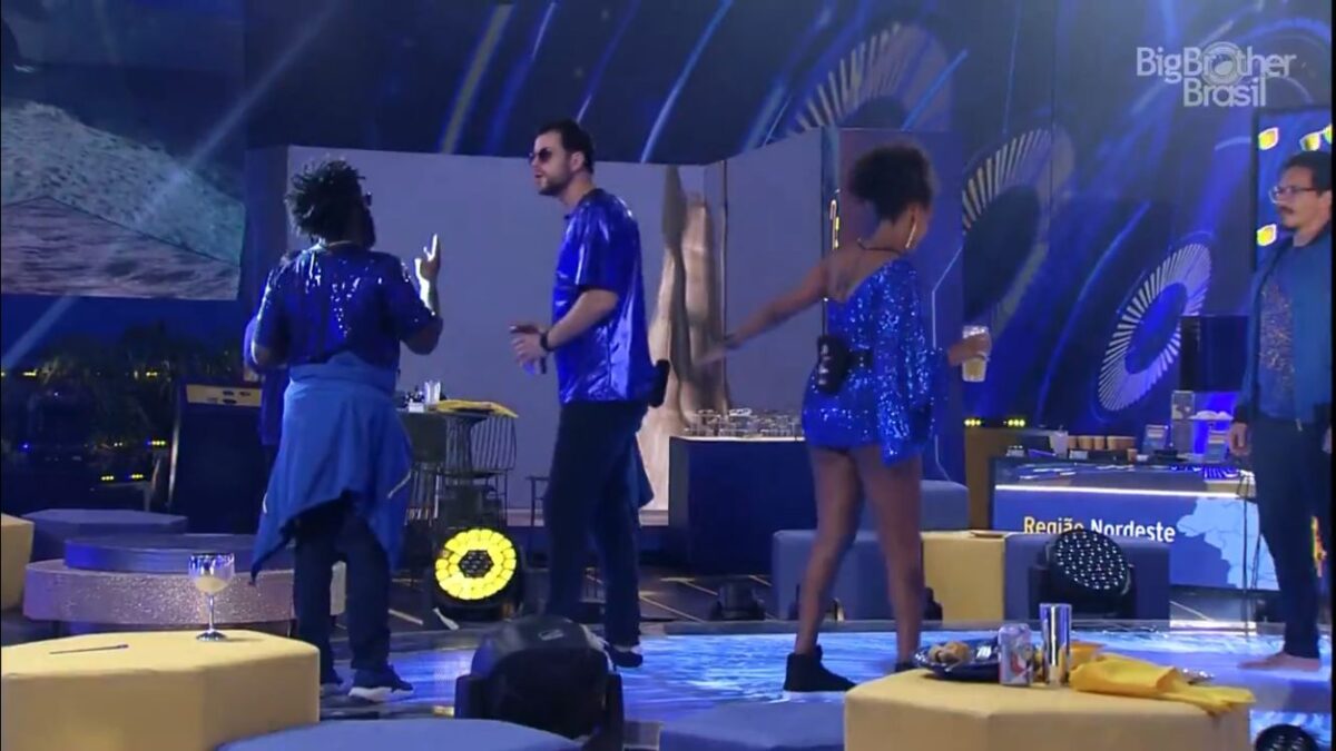 Douglas de frente para Gustavo com o dedo apontado. Do outro lado, Jessi dançando com Scooby.