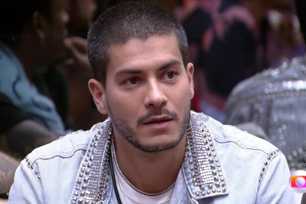 Arthur Aguiar sentado no so fá da sala do BBB 22 se preparando para o resultado do Paredão Falso