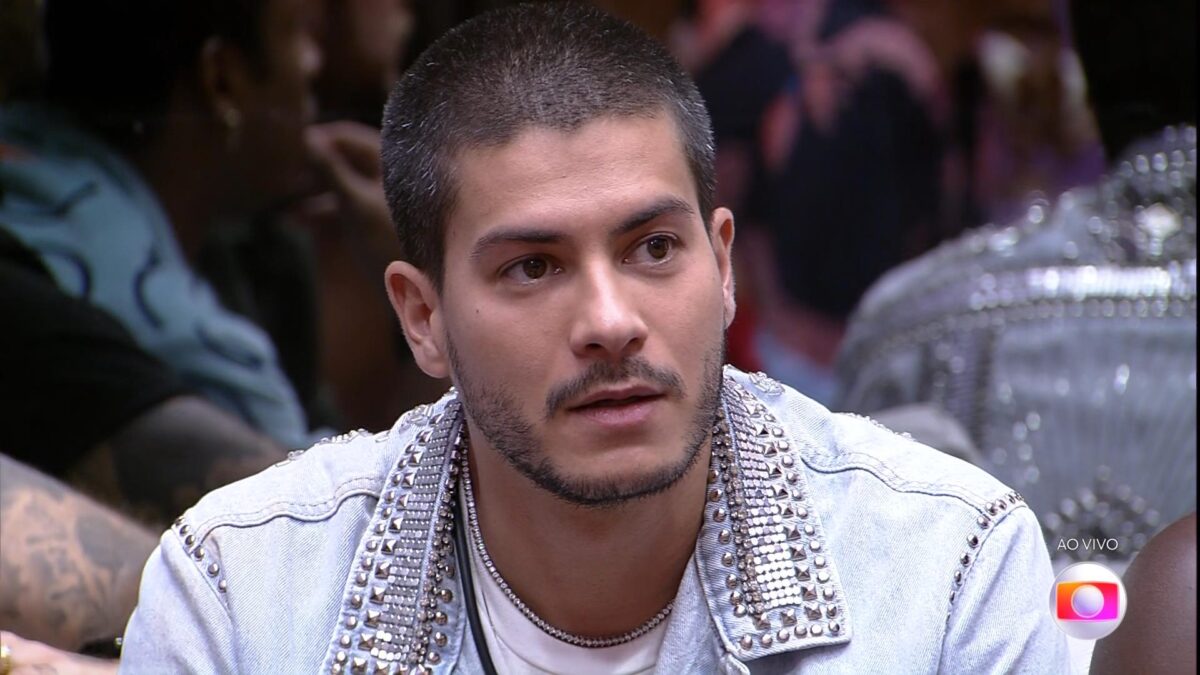 Arthur Aguiar sentado no so fá da sala do BBB 22 se preparando para o resultado do Paredão Falso