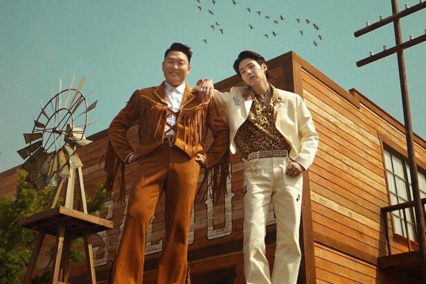 Psy e Suga abraçados em um cenário de faroeste