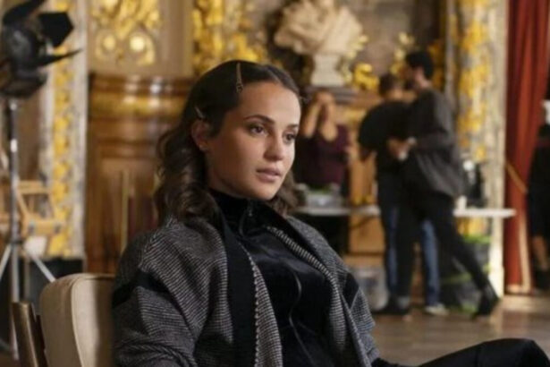 Alicia Vikander sentada em cena de Irma Vep