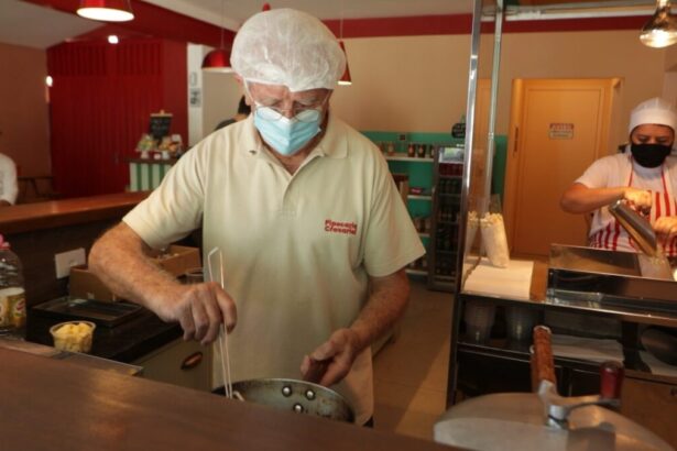 Homem trabalhando em uma cozinha de restaurante, em trecho do Arquivo A sobre emprego depois dos 50 anos