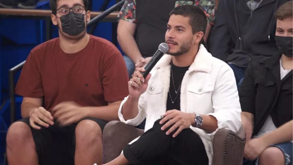 Arthur Aguiar sentado, participando do Altas Horas, no estúdio