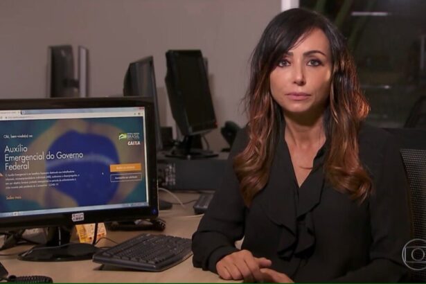 Elaine Bast em trecho de uma reportagem para o Jornal Nacional. Ela está sentada, ao lado de um computador de mesa