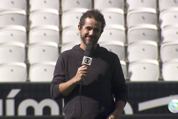 Felipe Andreoli com um microfone de mão apresentando o Globo Esporte direito do gramado da Arena Corinthians