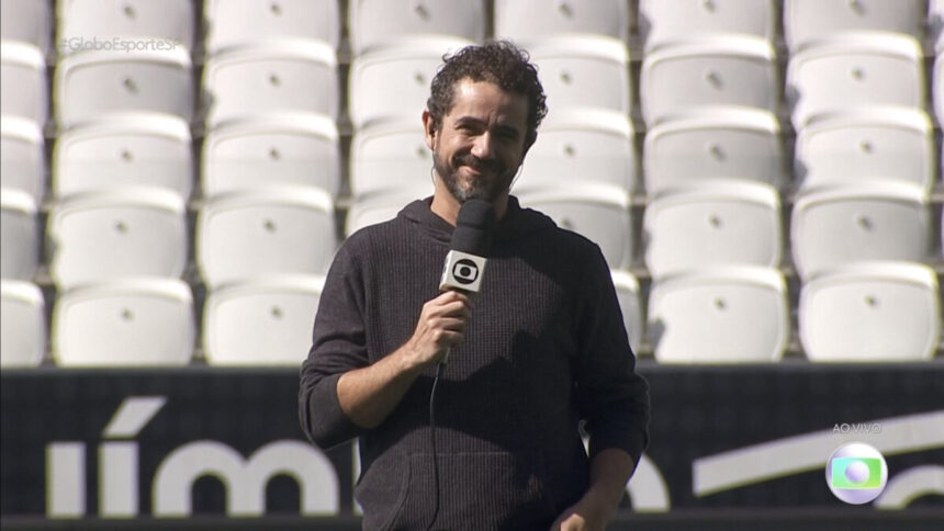 Felipe Andreoli com um microfone de mão apresentando o Globo Esporte direito do gramado da Arena Corinthians