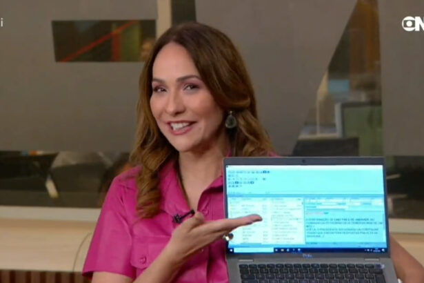 Maria Beltrão com um notebook nas mãos nos estúdios da GloboNews