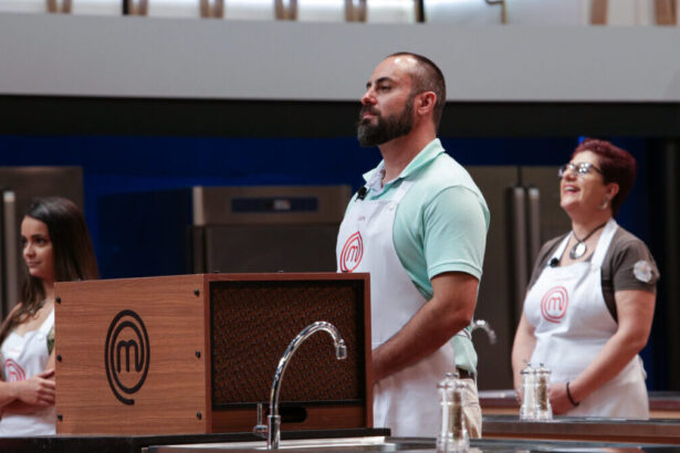 Trecho da estreia do MasterChef Brasil, com o desafio da Caixa Misteriosa na frente da imagem, com três participantes ao fundo