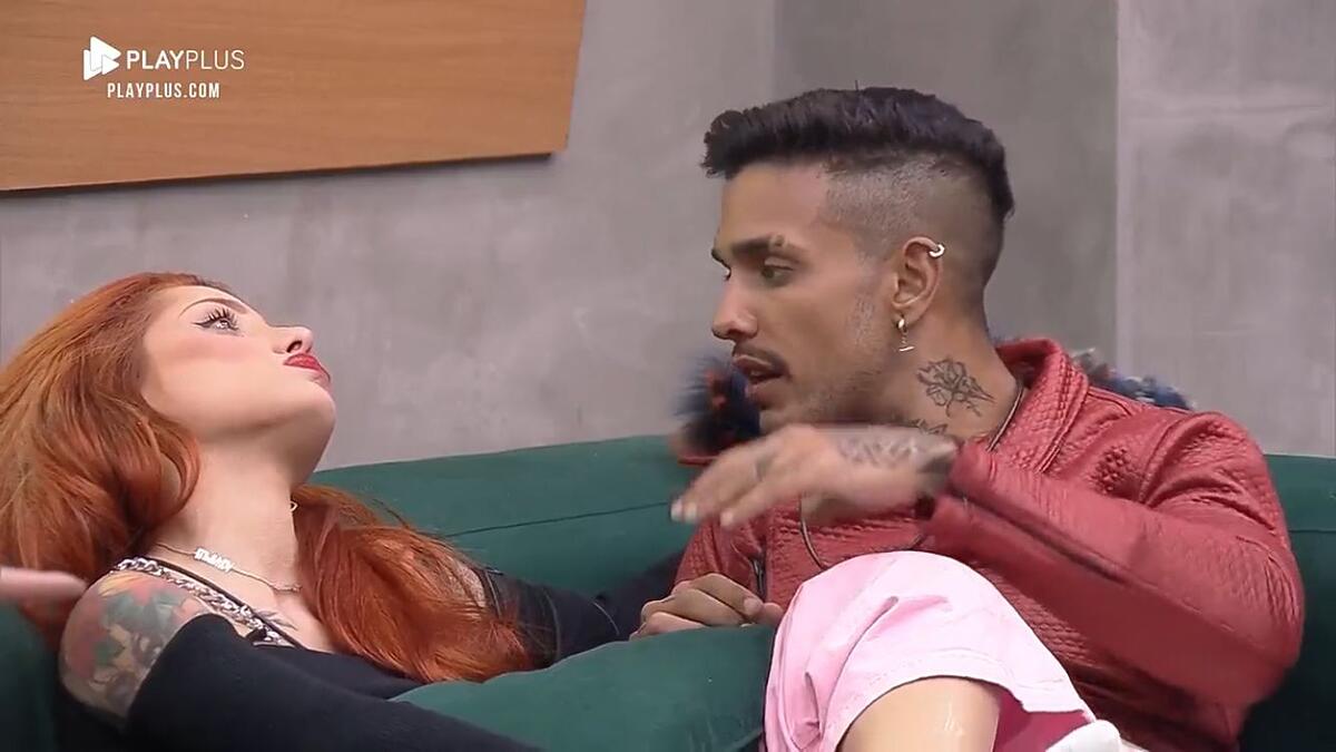 Matheus sentado no sofá ao lado de Brenda.