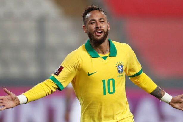 Neymar comemorando um gol com a camisa da Seleção, com os braços abertos