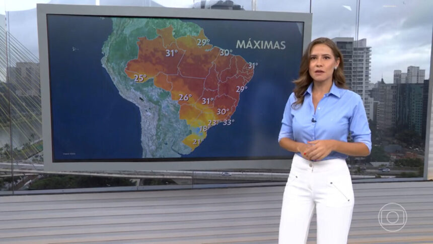 Thaís Luquesi, em frente ao televisor nos estúdios do Bom Dia Brasil em SP, com as informações do tempo