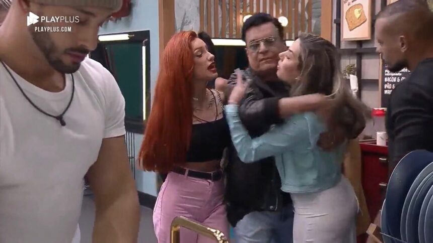 Brenda com as mãos para trás Nahim no meio entre ela e Karol.