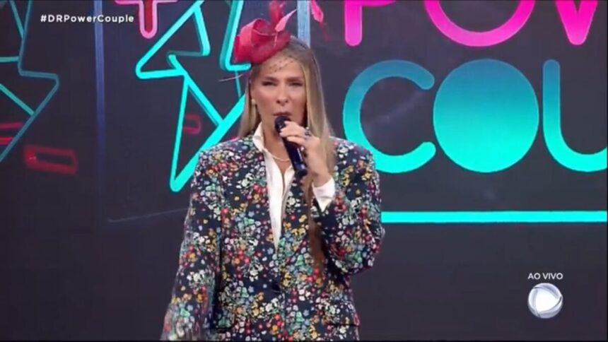 Adriane Galisteu com roupa estampada no cenário do Power Couple.