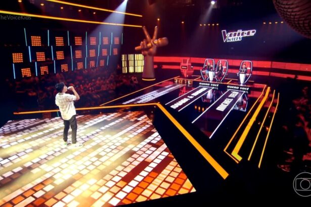 Mateus Cassemiro cantando no centro do palco do The Voice Kids