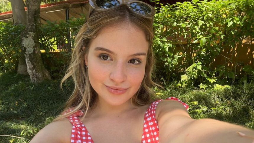 Sophia Valverde faz selfie com óculos escuro e vestido de bolinhas vermelho