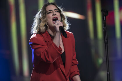 Ariane Villa Lobos se apresentando na semifinal do Canta Comigo, utilizando uma roupa vermelha