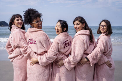 Manoela Aliperti , Heslaine Vieira , Ana Hikari , Gabriela Medvedovski e Daphne Bozaski de roupão em frente a praia