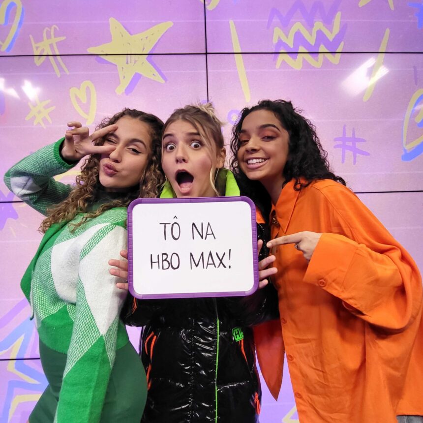 A banda BFF Girls com uma placa nas mãos dizendo que estão na HBO Max