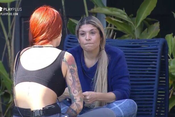 Brenda de costas para Adryana na área externa do Power Couple.