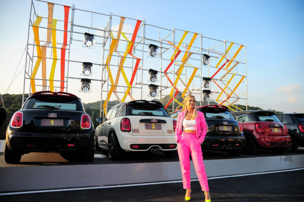 Eliana em frente aos carros no estacionamento do SBT