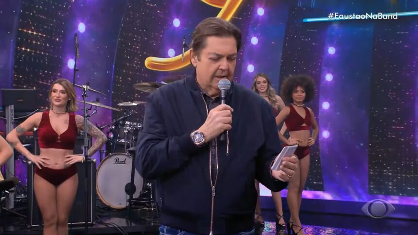 Faustão em trecho do Faustão na Band. Ele está lendo um papel na sua mão