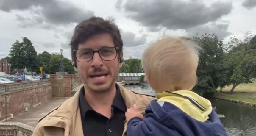 Felipe Kieling fazendo uma entrada ao vivo em um campo aberto e com o filho Lucas no colo