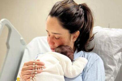 Fernanda Vasconcellos segurando o pequeno Romeo no colo, em uma cada de hospital na maternidade