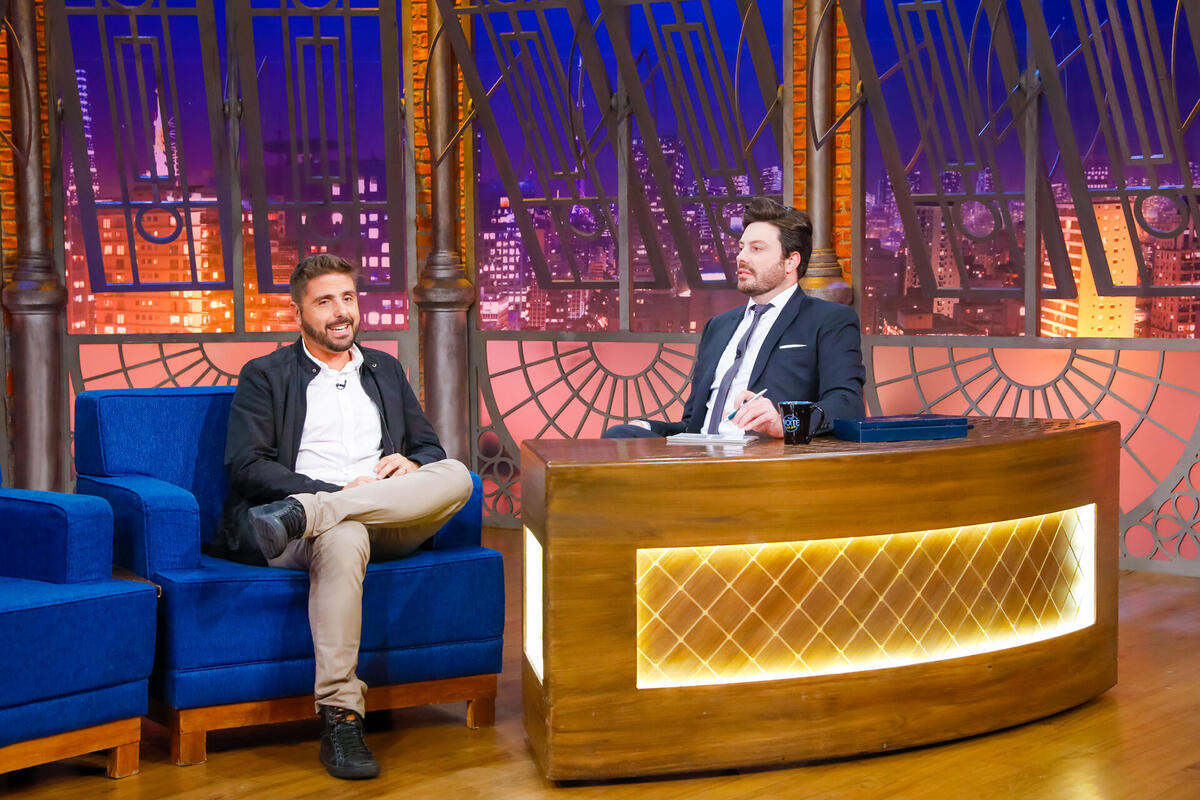 Jorge Nicola, sentado nos estúdios do The Noite, ao lado de Danilo gentili em trecho da entrevista