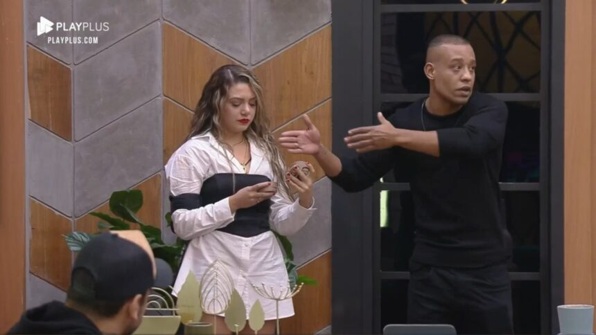 Karol e Mussunzinho próximo ao quadro de distribuição dos quartos do Power Couple Brasil 6