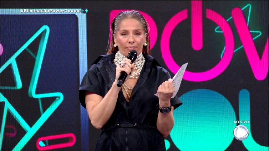 Adriane Galisteu com a carta de Michele e Passa nas mãos no estúdio do Power Couple Brasil 6