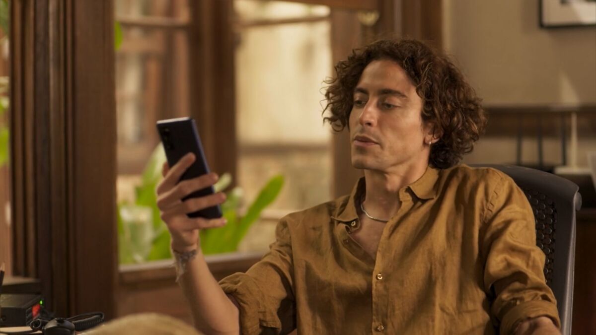 Jesuíta Barbosa (Jove) em cena da novela Pantanal, com um celular nas mãos
