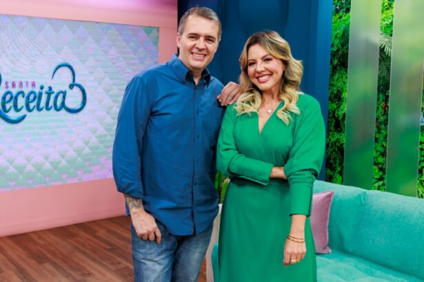 Apresentadores Abiane Souza (vestido verde, cabelo solto, sorrindo) ao lado de Leonardo Roncon (camisa azul e calça jeans, sorrindo) durante gravação do Santa Receita, da TV Aparecida