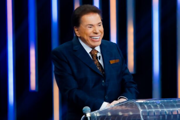 Silvio Santos sorrindo, de palitó e gravata na bancada do Troféu Imprensa, do SBT