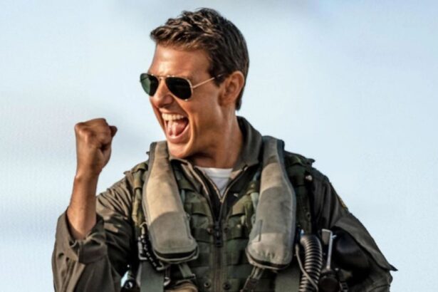 Tom Cruise com óculos de sol, fardamento, vibrando durante gravação do filme Top Gun, da Paramount