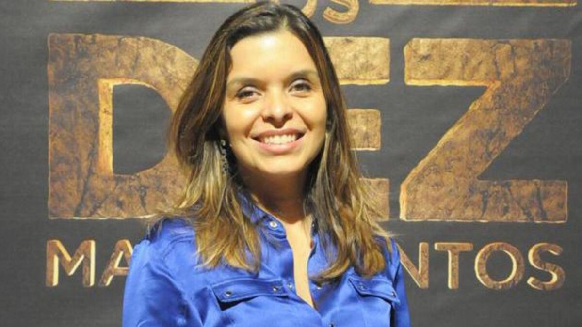 Vivian de Oliveira em frente ao banner com o logo da novela Os Dez Mandamentos
