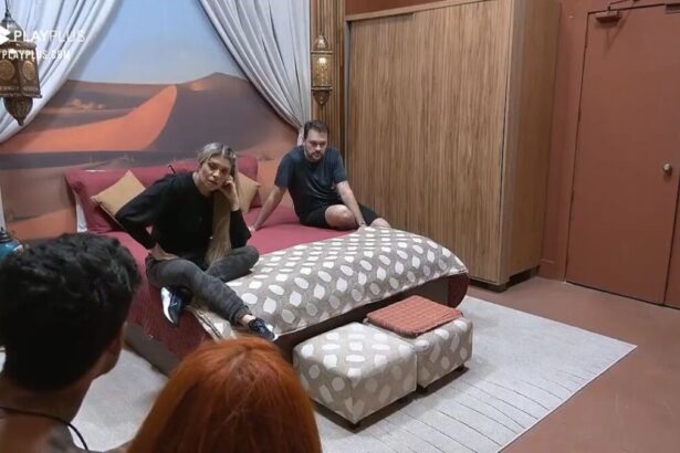 Albert e Adryana sentados na cama no Power Couple. De costa na imagem aparece Brenda e Matheus.