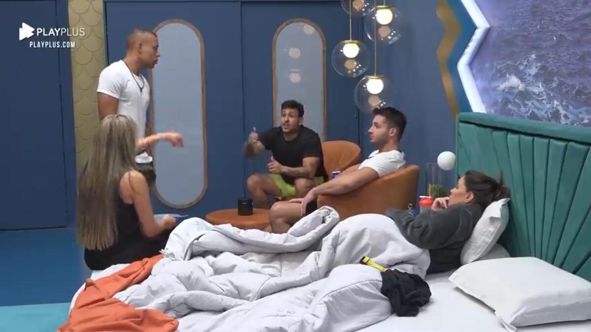 Mussunzinho em pé ao lado de Karol sentada na cama próxima de Ivy. Nandinho sentado ao lado de Hadad na suíte power.