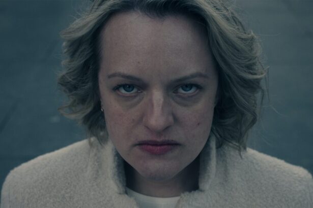 June Osborne, personagem de Elisabeth Moss, olhando para câmera concentrada durante gravação de The Handmaid's Tale