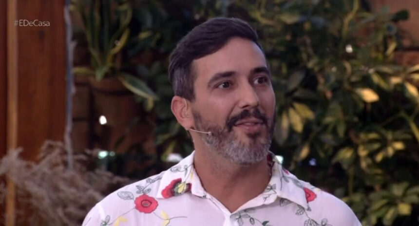 André Marques com uma blusa florida no É de Casa, na área externa dos estúdios