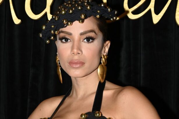 Anitta com um chapéu preto, em foto posada nos bastidores de um evento