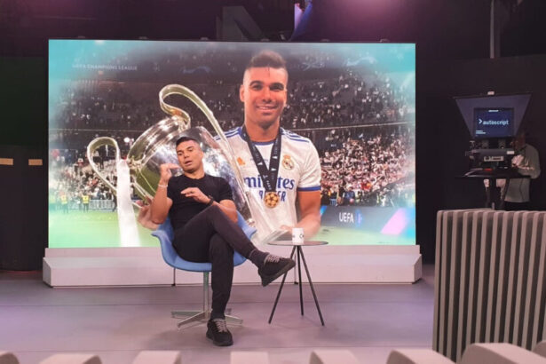 Casemiro em trecho da entrevista para o Grande Círculo, em frente a um telão com sua imagem vestindo a camisa do Real Madrid projeta