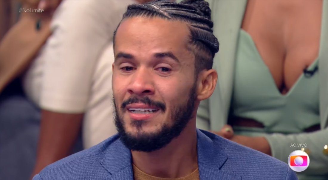 Charles com penteado em trança, chorando, durante gravação da final do No Limite, da TV Globo