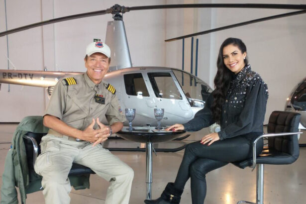 Comandante Hamilton de frente para Daniela Albuquerque, em trecho da entrevista, com um helicóptero ao fundo