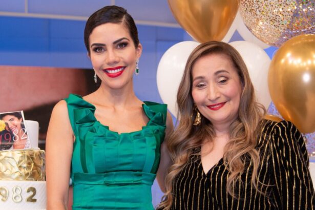 Dani Albuquerque de vestido verde, sorrindo, abraçando Sonia Abrão em frente ao cenário do seu aniversário no programa Sensacional, da RedeTV!