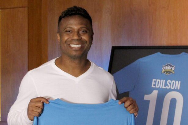 Edilson Capetinha segurando uma blusa azul, com o logo Galera Esporte Clube