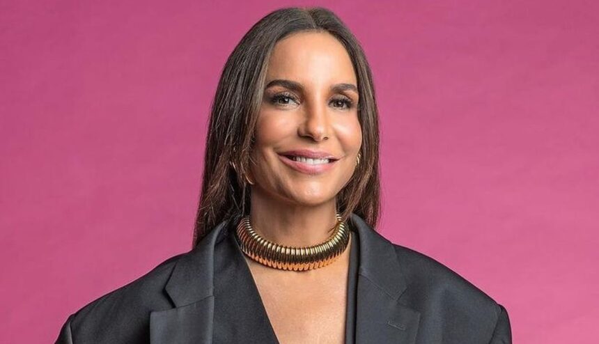 Ivete Sangalo de blazer e camisa preta, colar, sorrindo durante photoshoot para o Pipoca da Ivete, da TV Globo